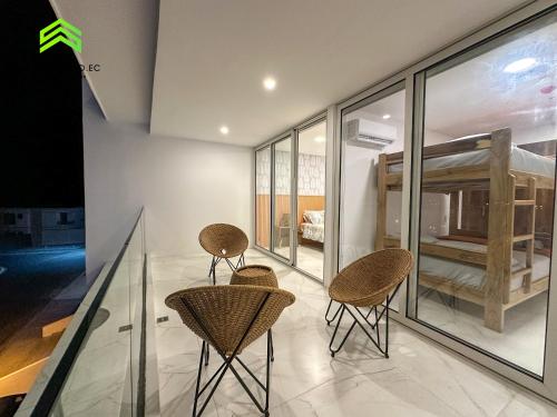 a room with three chairs and a crib at Departamento frente al mar, con piscina en Manta in Manta