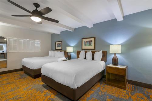 a bedroom with two beds and a ceiling fan at Best Western Plus Jekyll Island in Jekyll Island