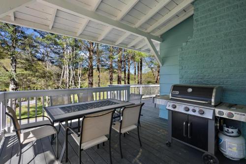 a screened porch with a grill and a table and chairs at Nature Sounds Retreat in Boone