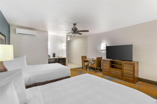 a hotel room with two beds and a flat screen tv at Best Western Plus Jekyll Island in Jekyll Island