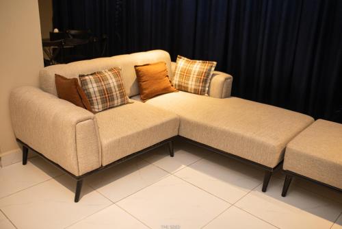 a couch and a ottoman in a living room at The Seed Plaza in Kumasi