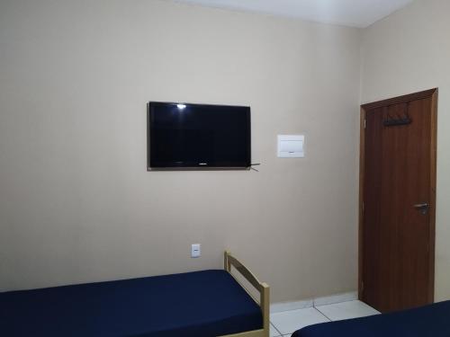 a bedroom with a bed and a flat screen tv on the wall at Casa Prizon in Olímpia