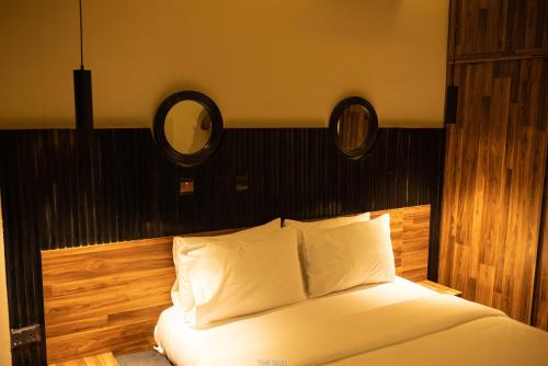 a bedroom with a white bed with a black headboard at The Seed Plaza in Kumasi