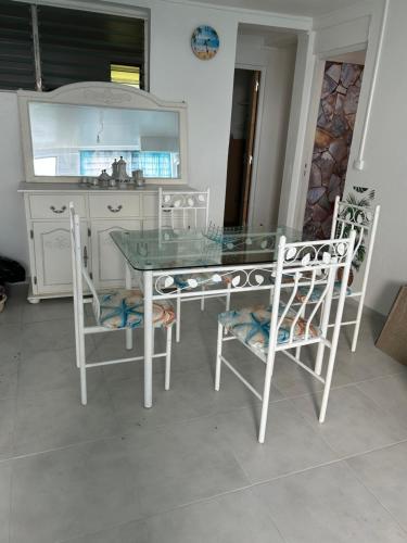 a dining room table and chairs with a mirror at Dolce Vita Emilia in Sainte-Luce