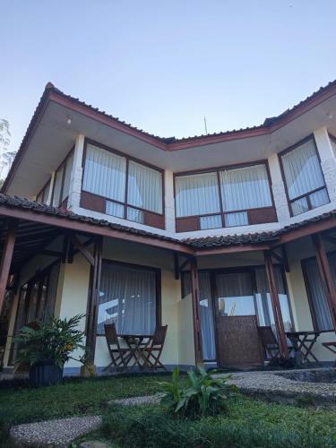 a building with chairs in front of it at Nur Alam Hotel Lembang in Lembang