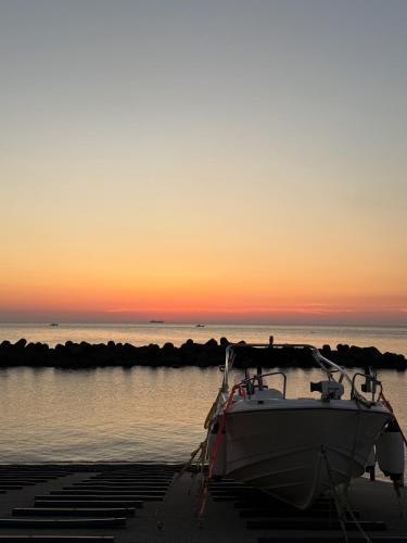 a boat is docked on the beach at sunset at 越前シーサイドゲストハウス オーシャンズ Echizen Seaside Guesthouse OCEAN'S in Fukui