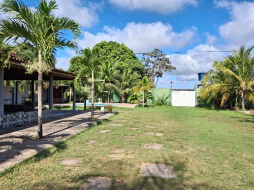 ein Hof vor einem Haus mit Palmen in der Unterkunft Chácara Recanto dos Poetas in Macajatuba