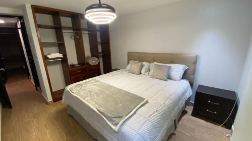 a bedroom with a bed in a room with a light at Cozy Modern 3 Bedroom Apartment in Guatemala City in Santa Rosita
