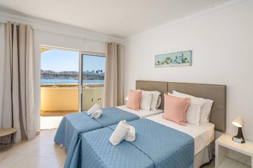 Dos camas en un dormitorio con vista al mar. en Sol e Praia - Ferragudo, en Ferragudo