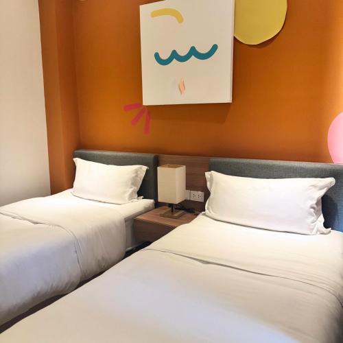 two beds sitting next to each other in a room at Luxebridge Hotel in Davao City