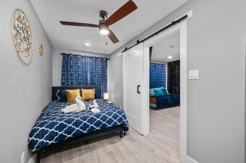 a bedroom with a blue bed and a ceiling fan at Bright and Airy 2BR with King Bed Free Parking and Pool in Houston