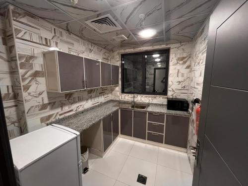 a kitchen with gray cabinets and a counter top at Aryaf Hotel Apart Tabasum Group in Ajman 