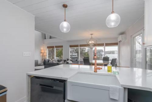 a kitchen with a white counter top and a living room at Lakeview Margaritaville -3bd3badecksdockgrill in Osage Beach
