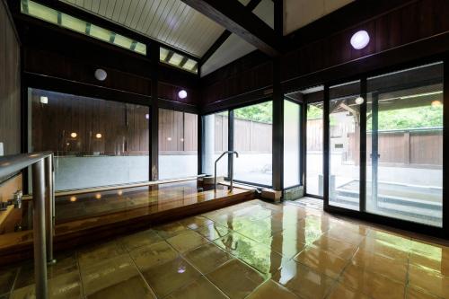 a large room with glass doors and a floor at Hotel Kikori in Hida