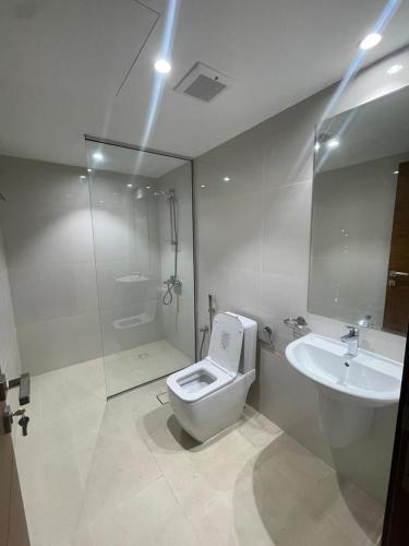 a bathroom with a toilet and a sink and a shower at Luxury 1BHK in Ghubrah