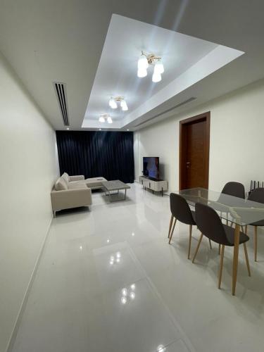 a living room with a table and chairs at Luxury 1BHK in Ghubrah