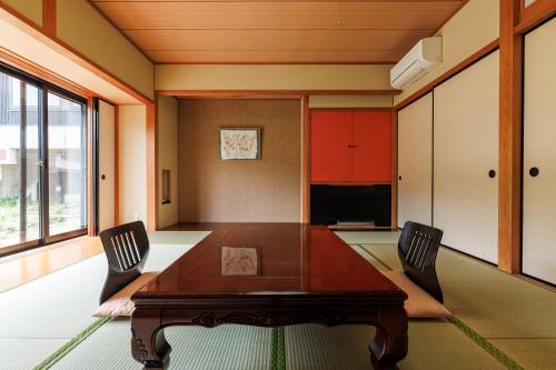 a dining room with a wooden table and chairs at Hotel Kikori in Hida