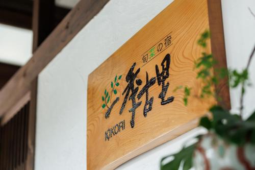 a wooden sign on a wall with writing on it at Hotel Kikori in Hida