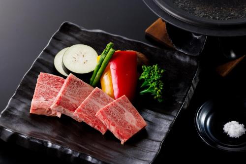 a plate of food with meat and vegetables on it at Hotel Kikori in Hida