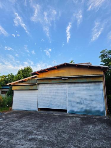 a pair of garage doors in front of a house at いすみエンガワのある古民家 in Isumi