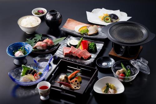 a table topped with different types of food on plates at Hotel Kikori in Hida