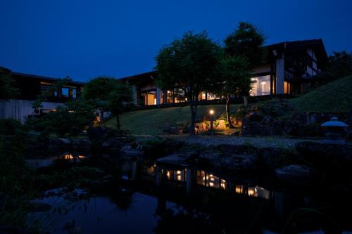 a building with a pond in front of it at night at Hotel Kikori in Hida