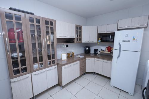 kuchnia z białymi szafkami i białą lodówką w obiekcie Apartamento aconchegante ideal para casais w mieście Campos dos Goytacazes