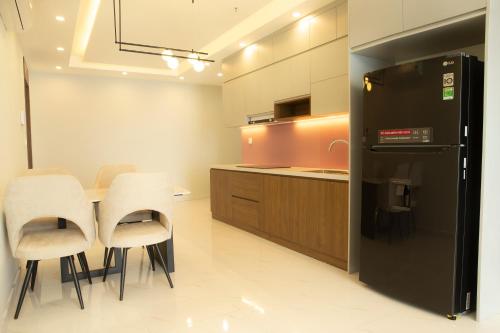 a kitchen with a table and chairs and a refrigerator at TSQ STAY Hotel Apartment in Hanoi