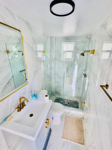 a white bathroom with a sink and a shower at Stylish Studio in Heart of Miami in Miami