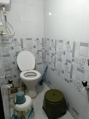 a bathroom with a toilet and a trash can at JAI SWAMiNARAYAN DELUX HOMESTAY in Garudeshwar