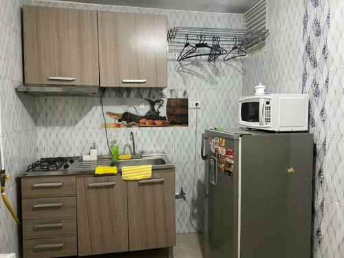 a small kitchen with a refrigerator and a microwave at IGE Hospedaje cerca al aeropuerto in Bogotá