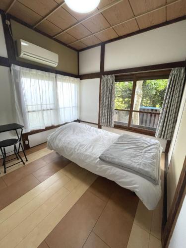 a bedroom with a bed in a room with windows at 懐かしい日本の家 nostalgic Japanese house For-R Uwamachi Share House in Yokosuka