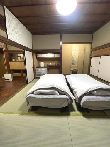 a room with two beds in a room with at 懐かしい日本の家 nostalgic Japanese house For-R Uwamachi Share House in Yokosuka
