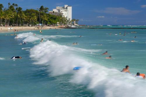 a group of people in the water at a beach at Waikiki Beach Ocean View King Bed & Free Parking in Honolulu