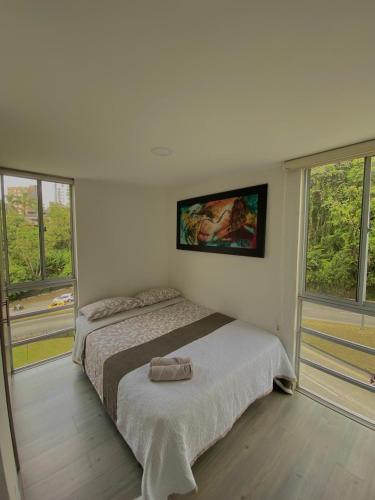a bedroom with a bed and two windows at Apartamento Urban Manizales in Manizales