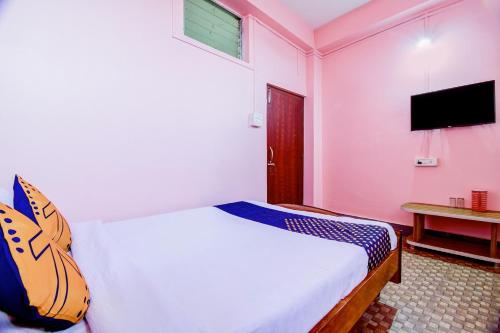 a bedroom with a bed and a flat screen tv at Hotel O NANDINI in Dibrugarh