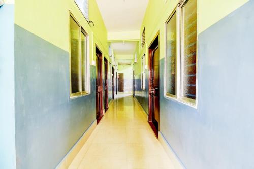 a hallway with blue and white walls and a tile floor at Hotel O NANDINI in Dibrugarh