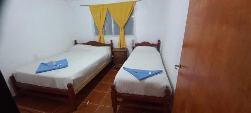 two beds in a room with blue towels on them at Hostal el rincón de cusi in Mina Pirquitas