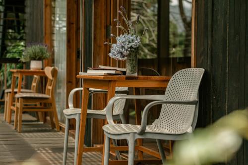 a table and chairs on a porch with a vase of flowers at Lavender Dalat Hotel and Resorts in Da Lat