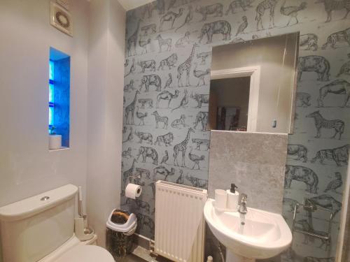 a bathroom with a sink and a toilet and a mirror at Cosy and spacious room in home with King Size bed in Nottingham