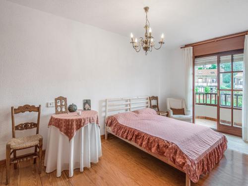 a bedroom with a bed and a table and a chandelier at Holiday Home in Loredo near Surf Beach in Loredo
