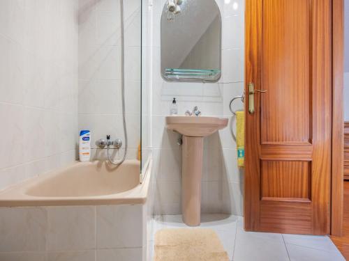 a bathroom with a sink and a tub and a toilet at Holiday Home in Loredo near Surf Beach in Loredo