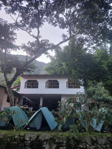 a house with a tent in front of it at Lia B&B Lucmabamba in Sahuayacu
