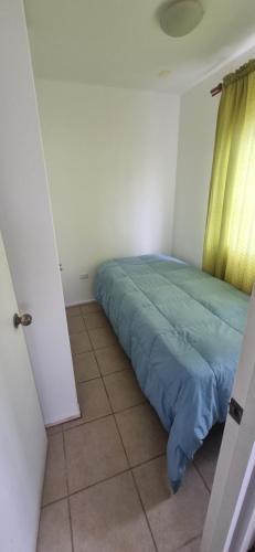 a bedroom with a bed with a green comforter at Casa villa los regidores 01 in Vallenar