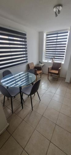 a living room with a table and chairs and windows at Casa villa los regidores 01 in Vallenar