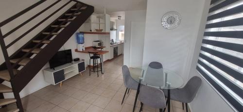 a dining room with a glass table and a staircase at Casa villa los regidores 01 in Vallenar