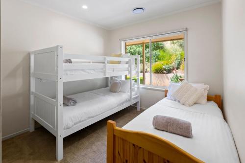Ένα ή περισσότερα κρεβάτια σε δωμάτιο στο Monkey Gully Retreat - Mansfield - Sleeps 9