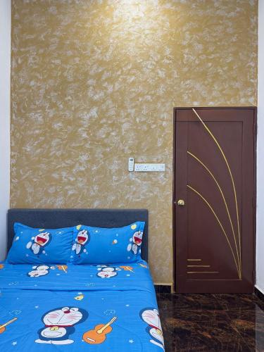 a bedroom with a blue bed and a brown door at Rifqi Ashraf Homestay Kota Bharu in Kota Bharu
