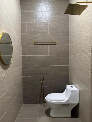 a bathroom with a toilet and a mirror at Rifqi Ashraf Homestay Kota Bharu in Kota Bharu