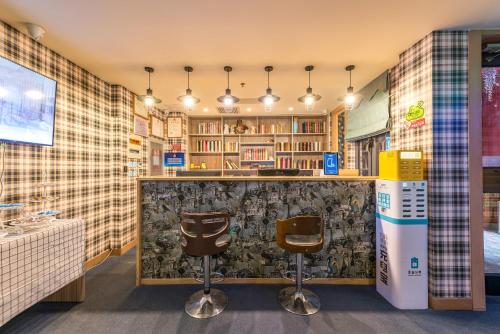 a bar in a room with two stools at Baihua Hotel in Beijing